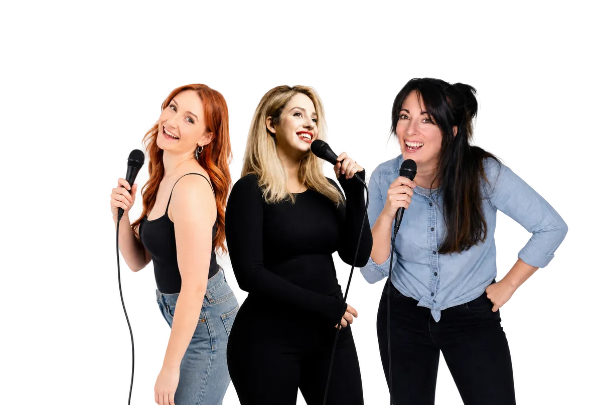 Three comedian hosts singing into microphones